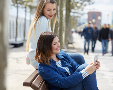 woman sitting on a bench looking at a phone