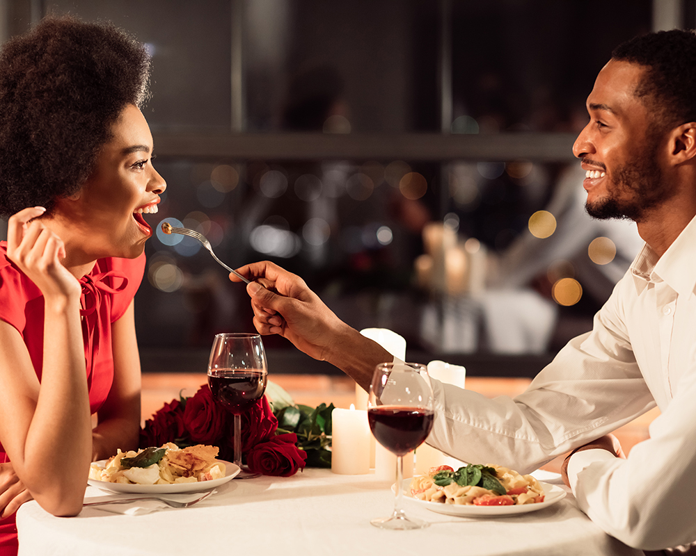 Romantic Date. Happy Couple Feeding Each Other Having Dinner